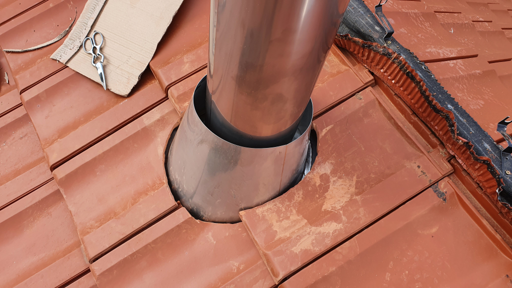 Ein Pappschablone hilft beim Zuschnitt der Dachziegel