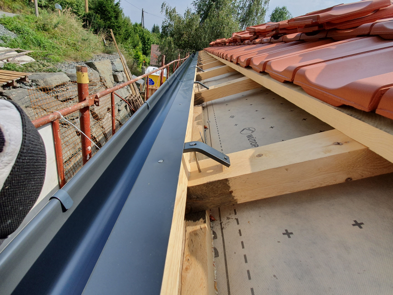 Installation der Dachrinnen, um Regenwasser abzuleiten | Haus-Selbstbau.com